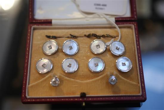 An early 20th century 9ct white gold, mother of pearl and diamond set eight piece dress stud set, in fitted box.